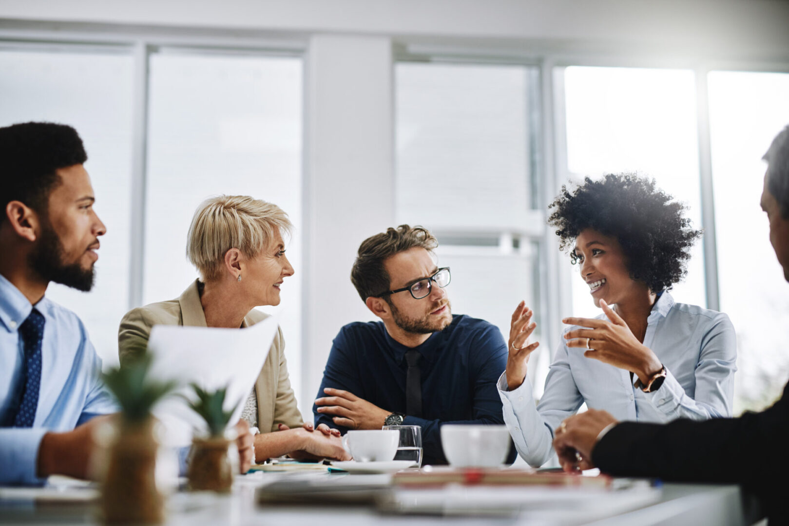 A group of people sitting around a table talking.