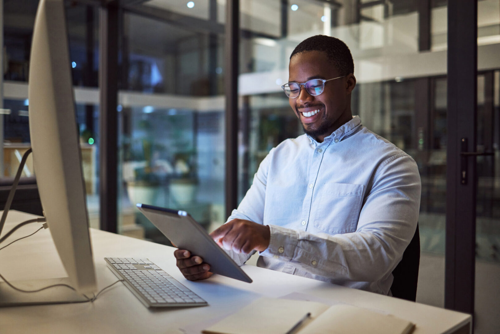 Businessman working on digital tablet late in office at night, happy and inspired by career goal. Motivation, management and vision by black entrepreneur excited by innovation and new company.