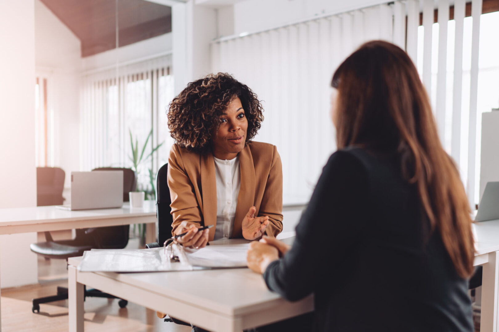 Two women are sitting at a table talking.