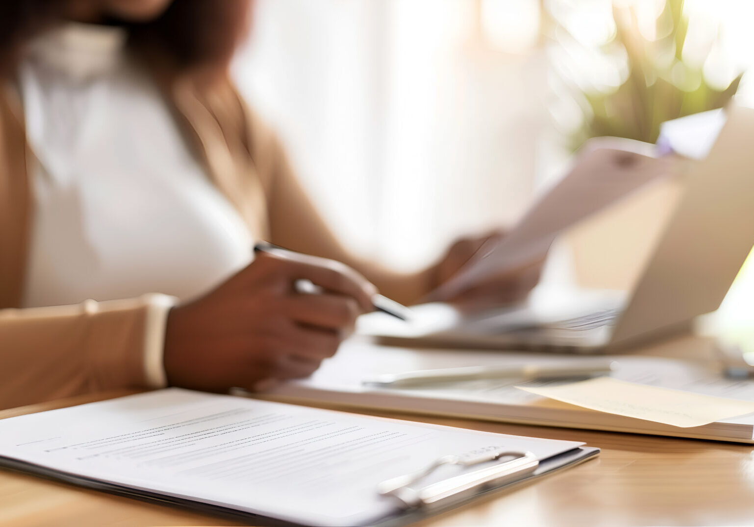 Close-up of businesswoman working with documents and laptop in office